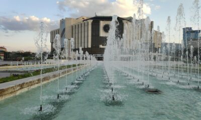 a large water fountain in front of a large building